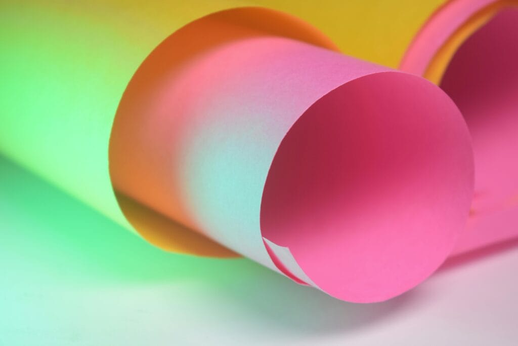 Vibrant close-up of colorful rolled papers creating an abstract pattern.